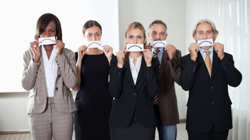a group of staff covering their mouth with a drawing of a sad face