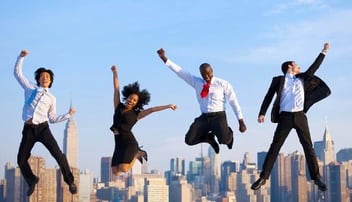 four people in business attires jumping with city building background