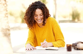 happy woman writing on her notebook