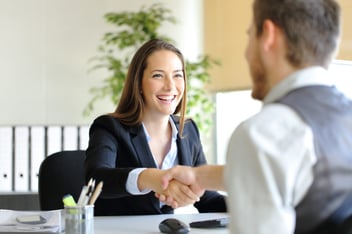 smiling woman shaking hands with new hired staff