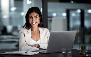 smiling woman in front of laptop