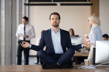 man in business attire meditating