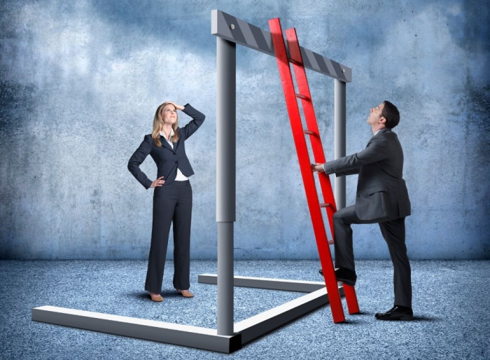 man in business attire holding a red ladder while a woman watches-700x514