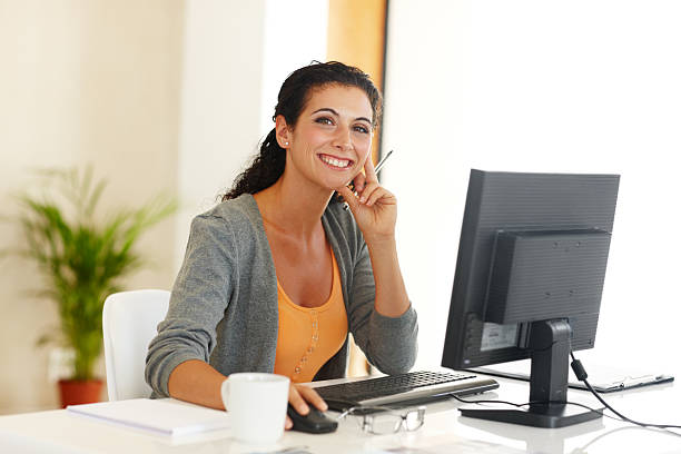 woman smiling in front of her computer
